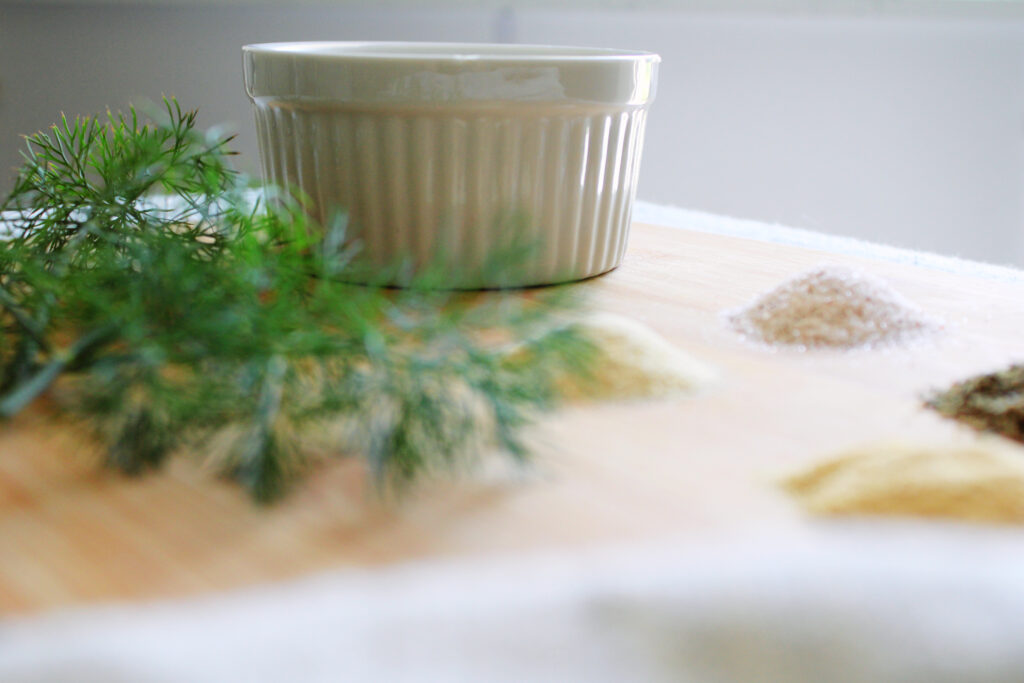White bowl with seasonings on a cutting board.