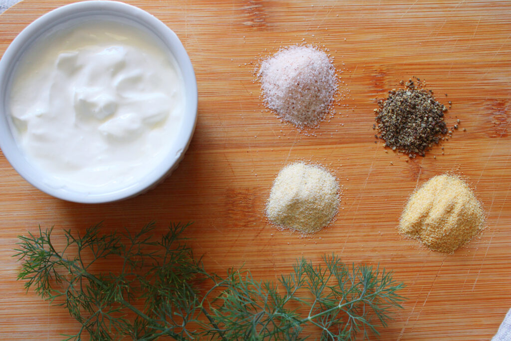 Sour cream and spices on a cutting board.