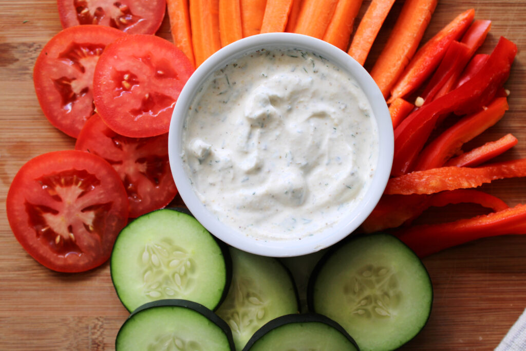 Ranch dip with vegetables around a small bowl.