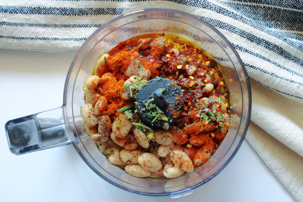 Spicy white bean dip ingredients in a food processor.