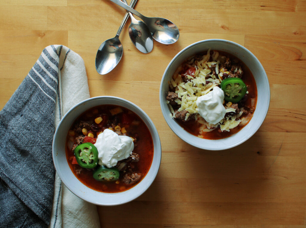 Slow cooker cowboy chili next to a tea towel.