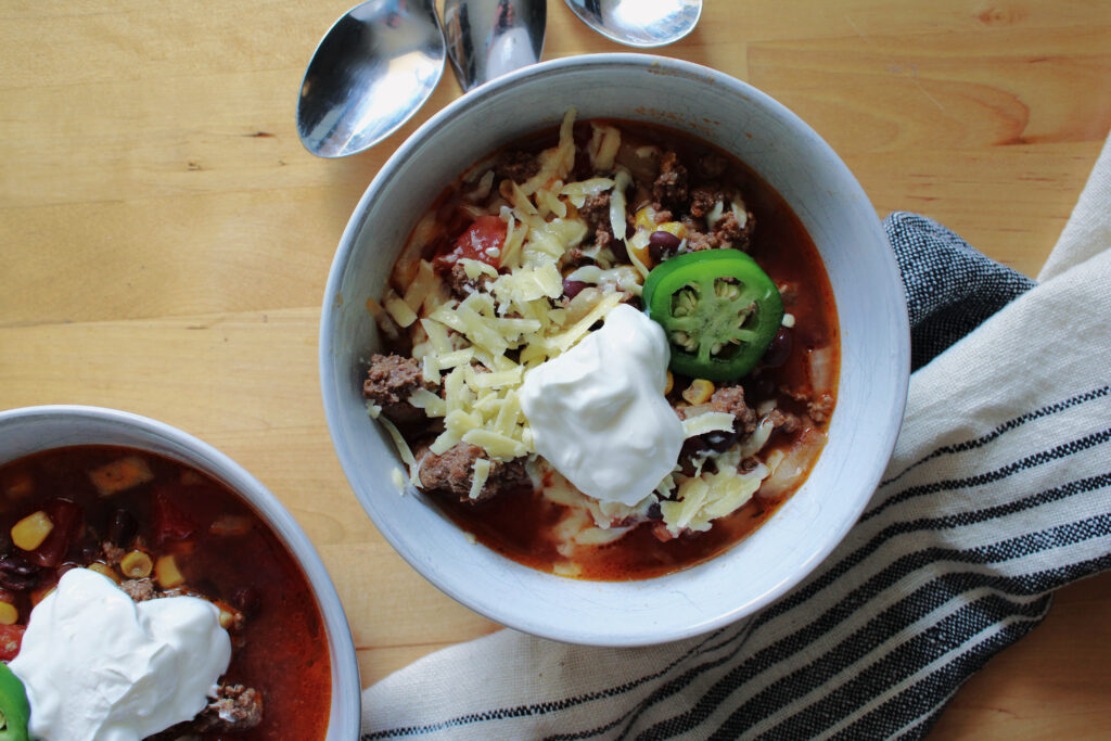 Slow cooker cowboy chili with sour cream on top.