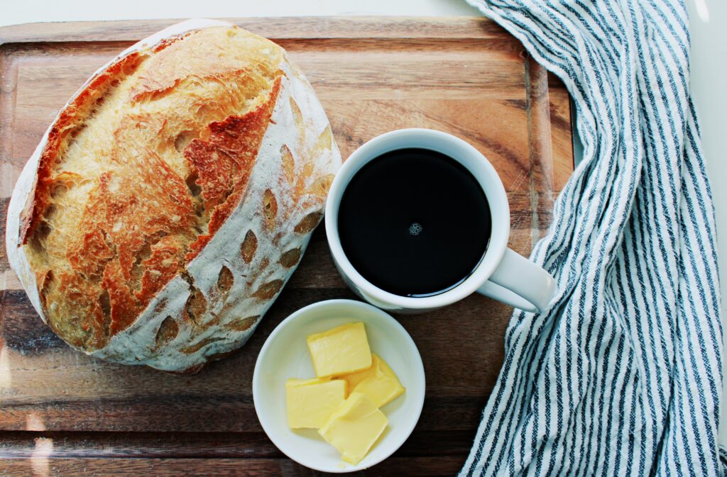 Same Day Sourdough on a cutting board with coffee and butter.