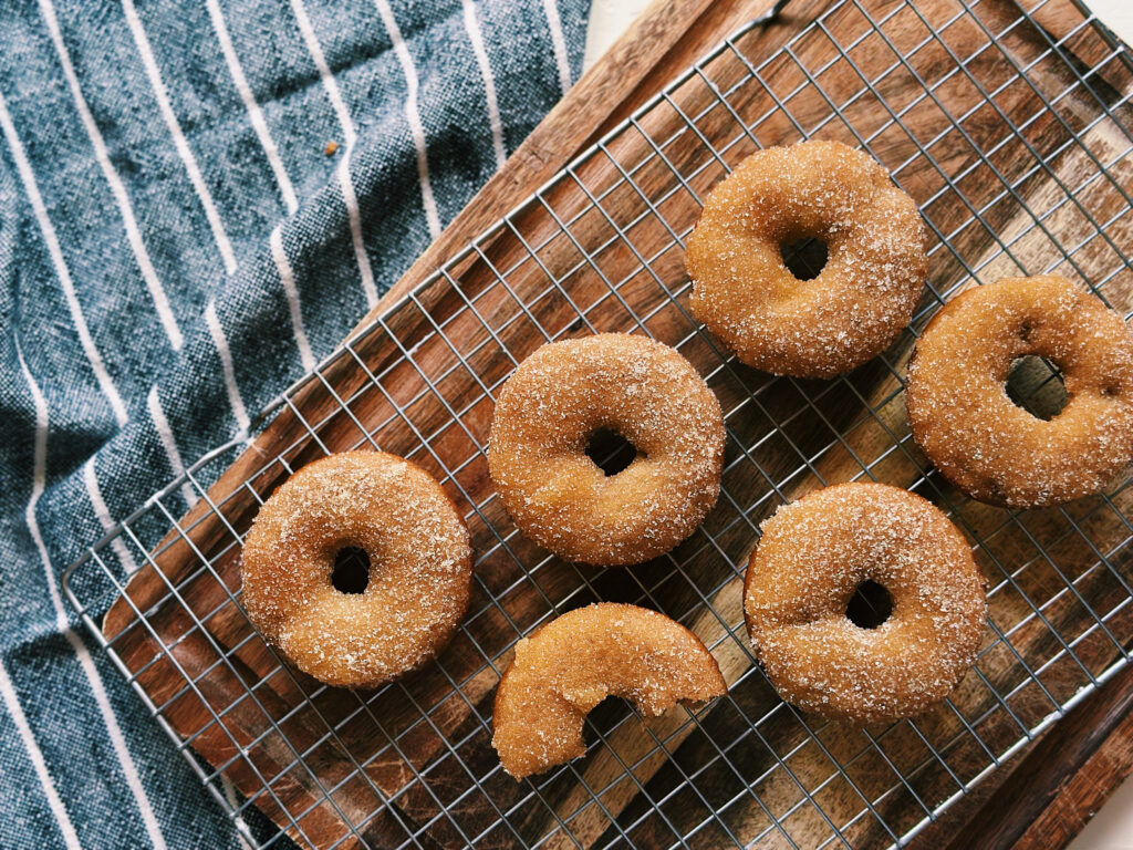 Incredible baked sourdough maple pecan donuts on a cooling rack.