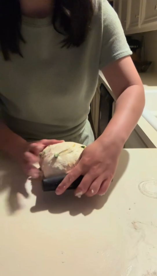 shaping the fall apple cinnamon sourdough with a bench scraper.