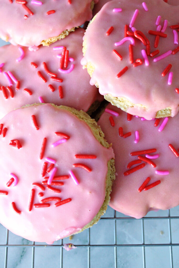 Frosted sourdough sugar cookies on a cooling rack.