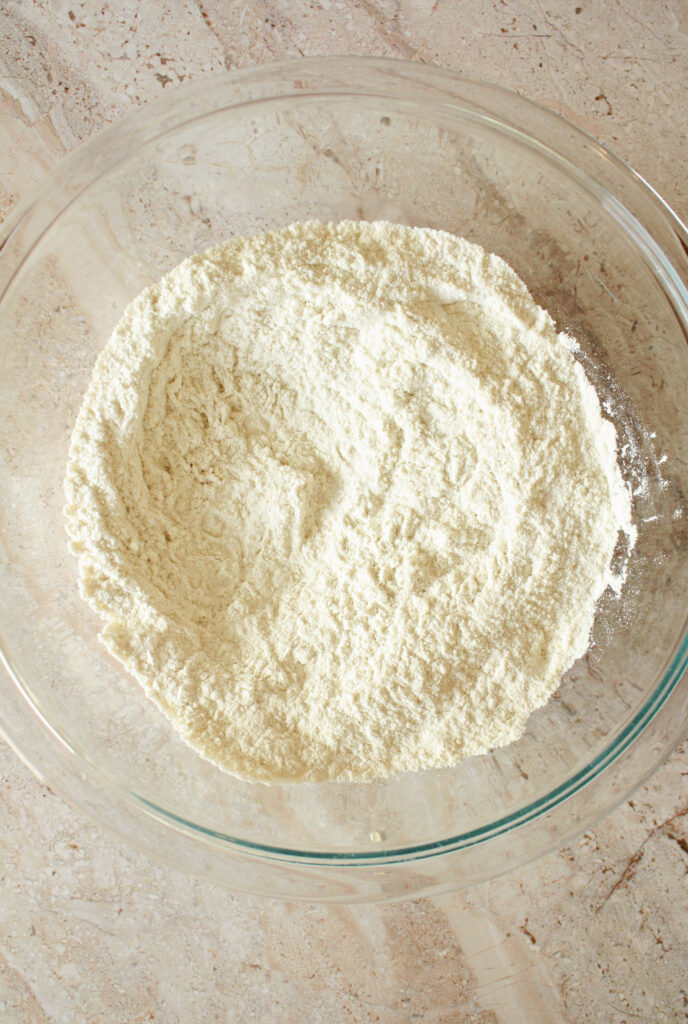 Dry ingredients for sourdough muffins are in a bowl on the counter.