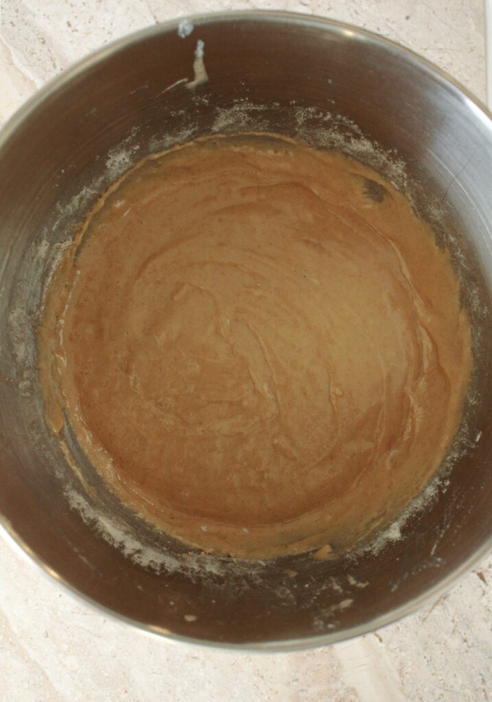 Dry and wet ingredients mixed together in a mixing bowl.