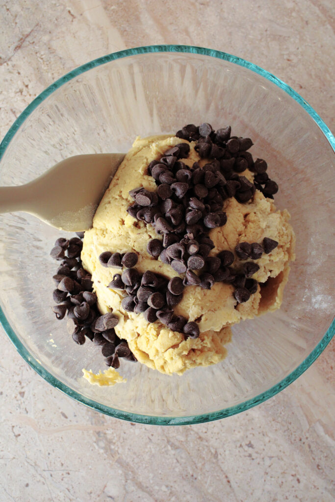 Sourdough chocolate chip scone dough in a bowl with chocolate chips on top.