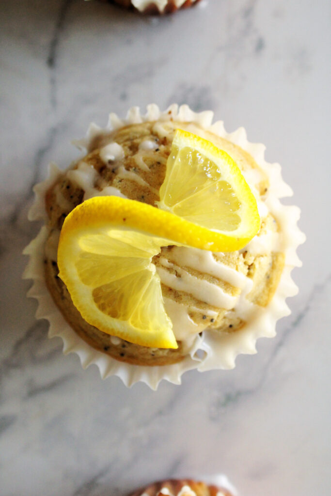 sourdough discard lemon poppy seed muffin with a lemon slice on top.