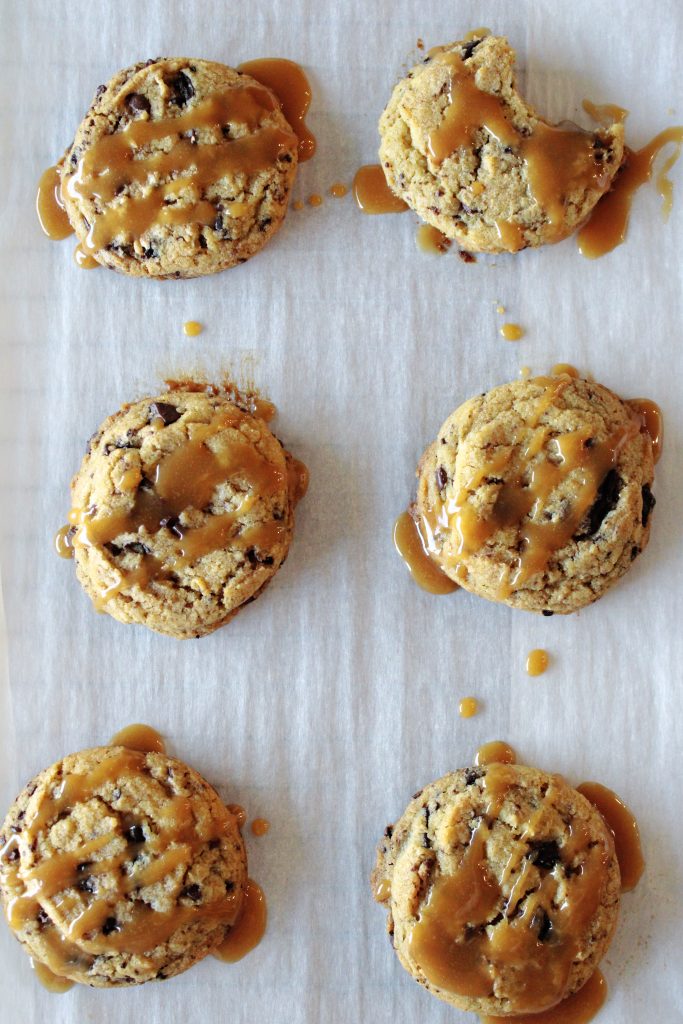 Salted caramel peanut butter cup cookies cooling on parchment paper.