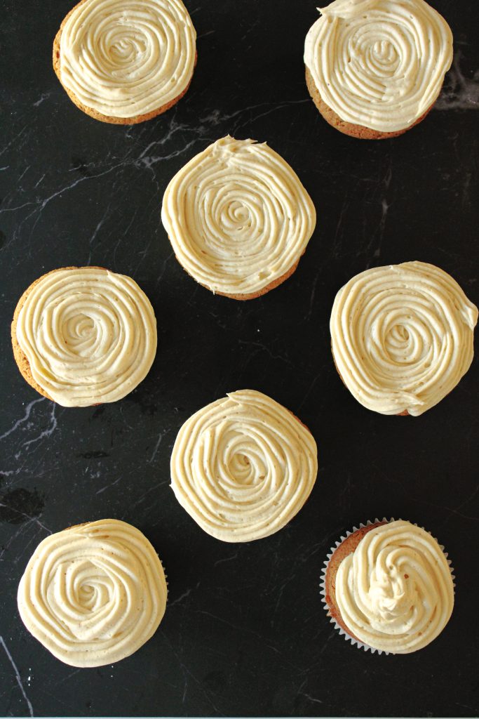Cinnamon Cupcakes with Cookie Butter Frosting sitting on the counter cooling.