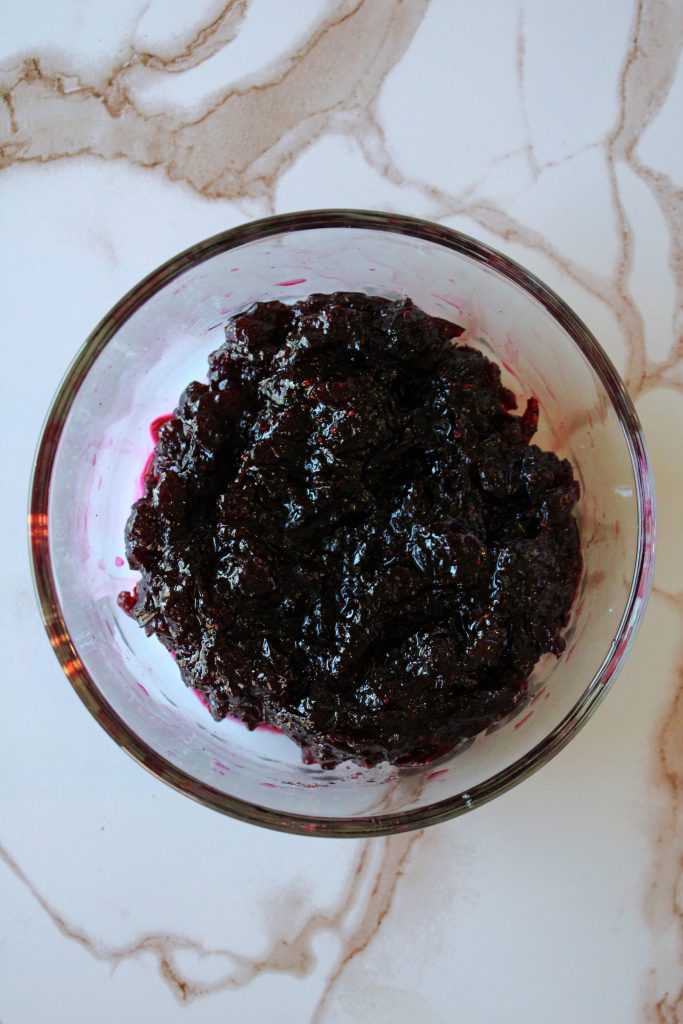 Cranberry orange jam in a clear bowl sitting on the counter.