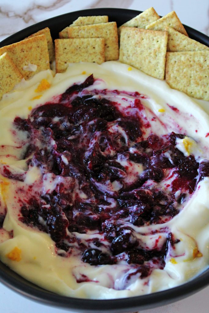 Crackers dipped in Holiday Cranberry Orange Whipped Ricotta.